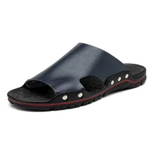 Détail d'une sandale pour homme en cuir bleu marine avec des accents de rivets argentés.