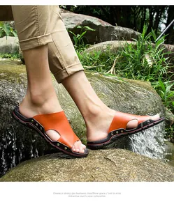Détail de sandales d'extérieur en cuir pour hommes sur des rochers près d'une cascade