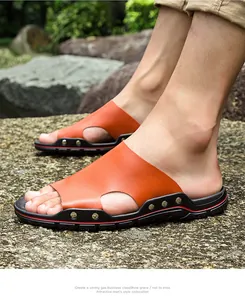 Mules en cuir orange pour hommes portées en extérieur avec semelle noire cloutée durable.