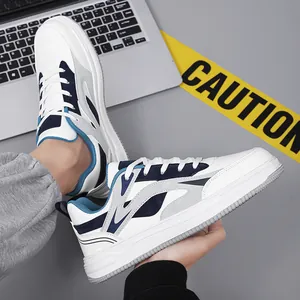 Fashionable men's chunky white sneakers with blue accents displayed in a casual setting