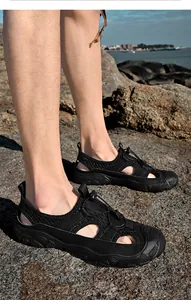 Vue détaillée des sandales de plage en maille pour hommes sur rivage rocheux