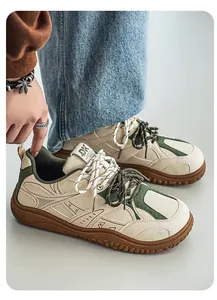 Close-up of retro wide-toe sneakers in cream and green with thick gum soles