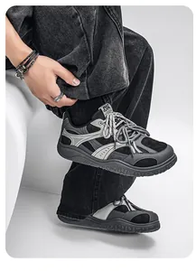 Close-up of retro wide-toe chunky sneakers with black denim jeans on a male model.