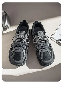 Close-up detail of stylish grey and black retro chunky sneakers with dual-tone laces