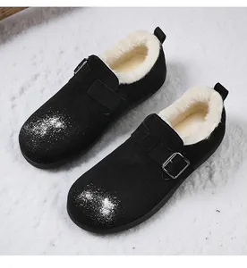 Detail of black suede Birkenstock style clogs with warm white faux fur lining in snow.