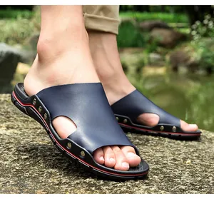 Vue détaillée des pantoufles en cuir bleu marine pour hommes avec rivets pour l'extérieur.