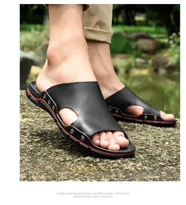 Détail de sandales noires en cuir pour hommes portées à l'extérieur sur pierre