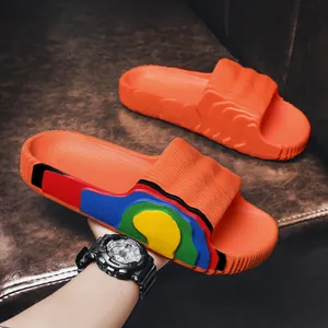 Comfortable bright orange summer slides with colorful rainbow wavy side pattern