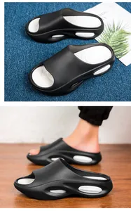 Dettaglio delle ciabatte spesse da uomo bianche e nere su superfici in moquette e legno.