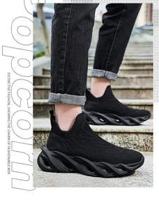 Vista laterale di sneaker nere traspiranti in fly-knit con suole spesse a onde su scale