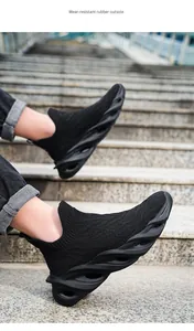 Dettaglio laterale di sneakers in maglia nera con suola ondulata spessa uomo