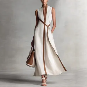 Elegant full body detail showing the fit of a sleeveless V-neck dress with brown trim