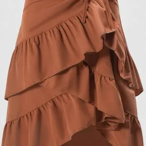 Primer plano de los elegantes volantes escalonados color terracota en falda de talle alto