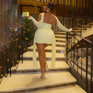 Vue arrière d'un ensemble robe courte en tulle jaune froncé avec rubans sur escalier