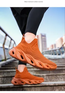 Dettaglio scarpe da corsa arancioni traspiranti fly-weave con suola in gomma spessa