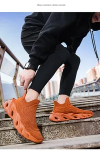 Dettaglio di scarpe da corsa in maglia arancione con suola in gomma resistente