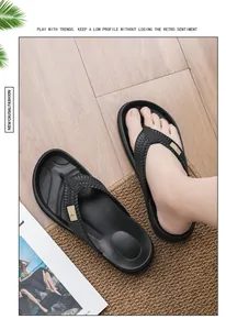 Comfortable black men's woven strap flip-flops displayed on a rustic wooden floor and jute mat