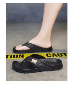 Detail view of men's black thick-sole flip-flops on industrial floor
