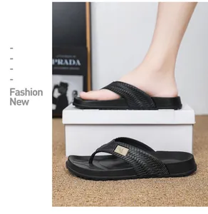 Close-up of black men's flip-flops with woven straps on a white display box.