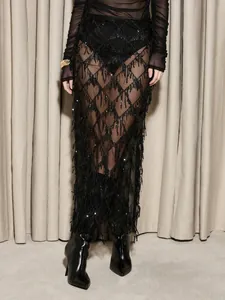 Détail d'une jupe sexy en maille noire avec des glands à paillettes