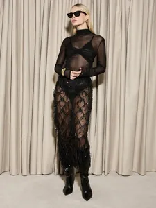Détail d'une jupe mi-longue à paillettes et franges noires portée par un mannequin