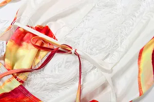 Detailansicht der weißen Fransen und des Neckholder-Bindebands am bunten bedruckten Kleid