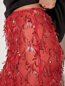 Vue rapprochée des détails complexes de franges à paillettes rouges sur une jupe.