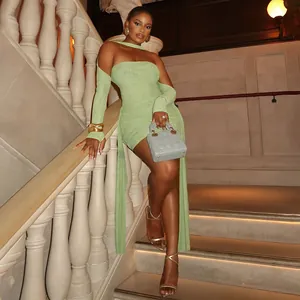 Vue complète d'un mannequin en robe licou en maille vert clair avec rubans sur un escalier