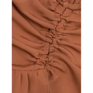 Vista macro detallada de la elegante tela fruncida en una falda midi marrón con volantes