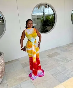 Colorful sleeveless tie-dye maxi dress with waist cutout and ring detail on model.