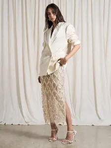 Jupe midi à paillettes champagne taille haute avec franges élégantes en décor de studio