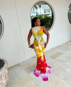 Close-up of a colorful tie-dye sleeveless cut-out maxi dress with a gold ring waist detail