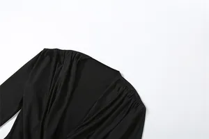 Detailweergave van het elegante gedrapeerde colhals detail op een zwarte bodysuit