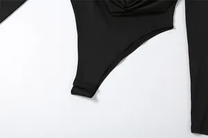 Macro-opname van de hoogwaardige drukknoopsluiting op een slanke zwarte body met lange mouwen