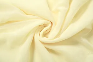 Gros plan détaillé du tissu en maille jaune clair avec texture fine et plis élégants