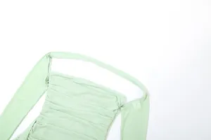 Gros plan détaillé du tissu en maille plissé vert clair avec col licou élégant