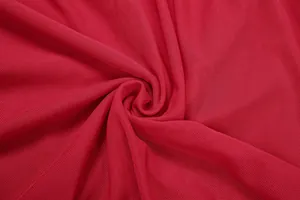 Vue macro détaillée du tissu en maille rouge vif avec une texture fine et des plis élégants