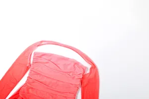 Gros plan détaillé d'une robe froncée en résille rose montrant sa texture fine