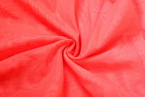 Détail rapproché d'un tissu en maille rouge vif respirant avec texture fine
