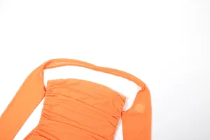Gros plan d'une robe orange vive en résille froncée à licou avec détails plissés