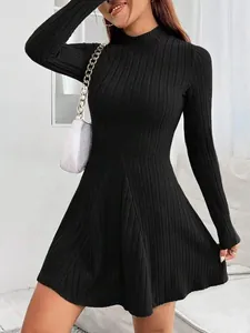 Detailed shot of a black slim fit ribbed long sleeve A-line dress with a high neck