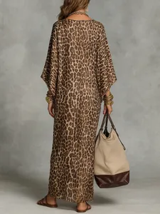 Back view of a woman in a bohemian leopard print maxi dress with large tote bag