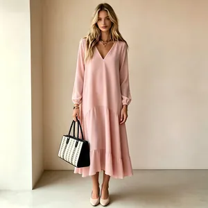 Vista de cuerpo entero de una mujer con un vestido maxi rosa de manga larga y cuello V