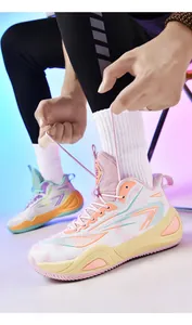Close-up of hands tying laces on vibrant color-blocking mid-top basketball shoes
