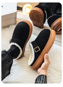 Detailed view of black fleece-lined platform clogs featuring a buckle strap and thick sole