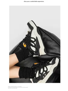 Close-up van retro chunky zwart-witte sneakers met dikke veters op zwart leer