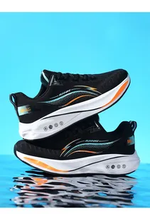 Vista laterale di scarpe da ginnastica nere da uomo con suola morbida e accenti arancioni