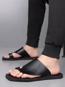 Gros plan de sandales en cuir noir pour hommes avec design à boucle d'orteil