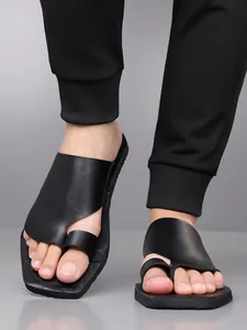 Gros plan de sandales élégantes à boucle d'orteil noires pour hommes avec un pantalon