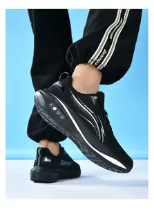 Vista laterale di scarpe da ginnastica nere da uomo con mesh traspirante e suola morbida.